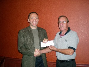 In November, Larry Bingaman (r), deputy regional vice president, presents an AFCEA Educational Foundation scholarship check to Frank Wilson. Wilson received an AFCEA Scholarship for Working Professionals, which will assist him in his pursuit of a Ph.D. He will use the degree as to work as a mathematics professor.
